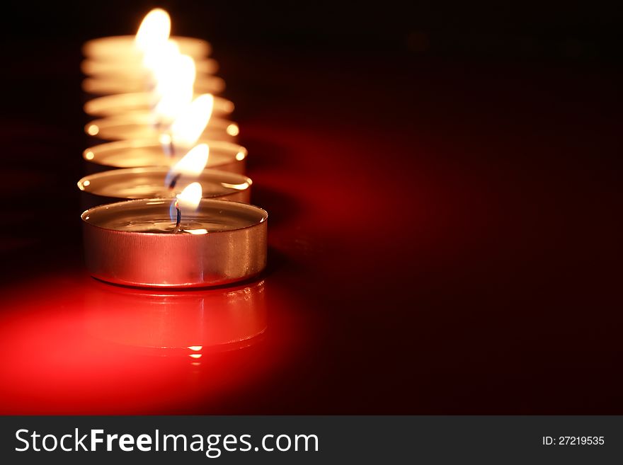 Set of lighting candles in a row on dark background with free space for text. Set of lighting candles in a row on dark background with free space for text
