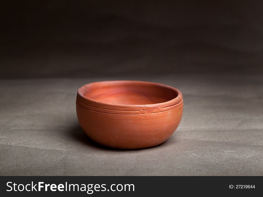 Close-up of soft clay pot over gray background. Close-up of soft clay pot over gray background