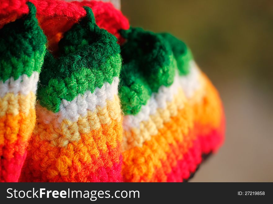 Beautiful multicolored handwoven woolen dress closeup photo. The colors of the cloth include red, orange, yellow, green and pink. Beautiful multicolored handwoven woolen dress closeup photo. The colors of the cloth include red, orange, yellow, green and pink.