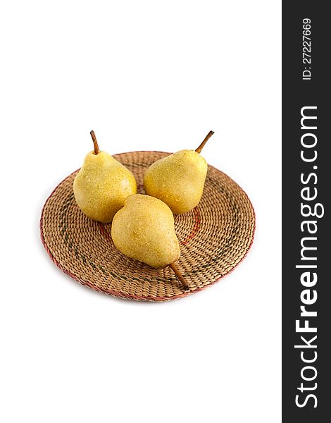Three pears on a straw mat