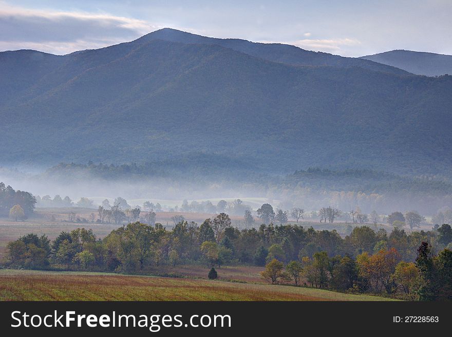 The sun rises over the fog and fields of Cades cove. The sun rises over the fog and fields of Cades cove.