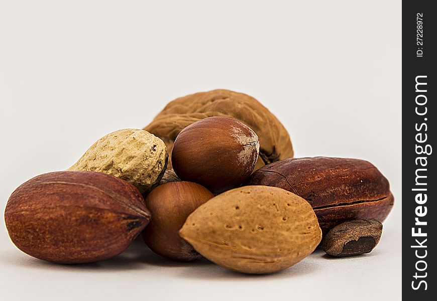 Assorted whole nuts - walnuts, pecans - on white background. Assorted whole nuts - walnuts, pecans - on white background