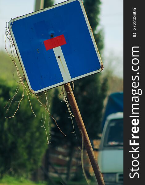 An Old Beveled Road Sign.  The Iconic Designation & X22 Dead End& X22 . Rural Road. An Old Truck In The Background.