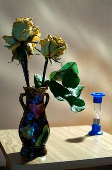 Vase With Yellow Roses And Hourglass Royalty Free Stock Photography