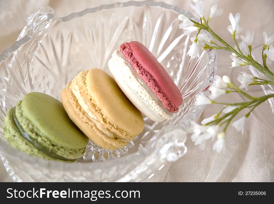 Colorful macarons put in glass basket with little flowers. Colorful macarons put in glass basket with little flowers