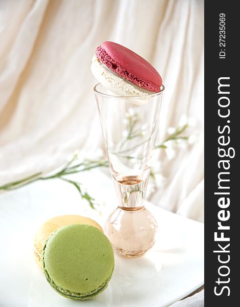 Macarons serve on white plate and pink glass. Macarons serve on white plate and pink glass