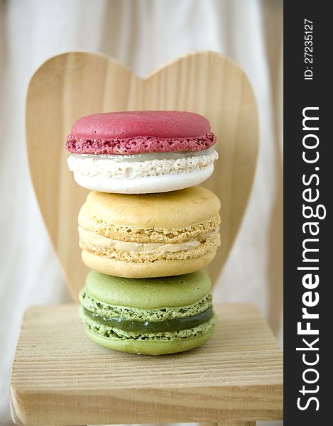 Stack of macarons on wooden heart shape background. Stack of macarons on wooden heart shape background