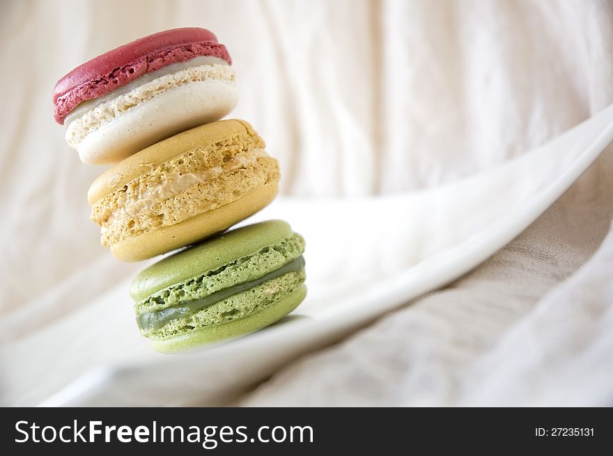 Stack of sweet macarons on white plate