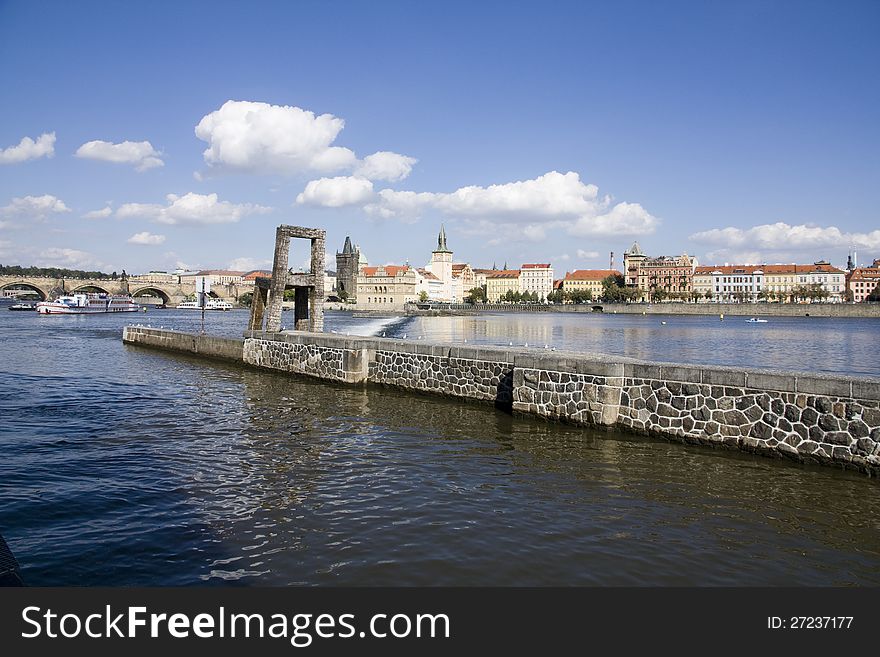 Large chairs on the pier, panorama of the vltava charles bridge in the background. Large chairs on the pier, panorama of the vltava charles bridge in the background