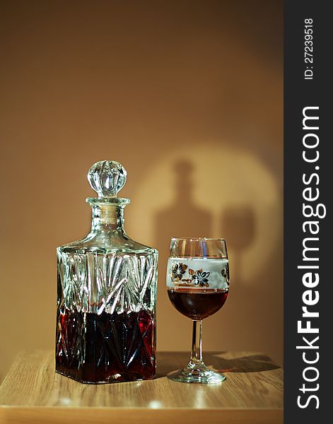 Crystal decanter with red wine and glass on the table. Crystal decanter with red wine and glass on the table