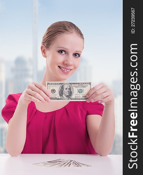 Young woman businesswoman sitting at the table with money, dollars. Young woman businesswoman sitting at the table with money, dollars