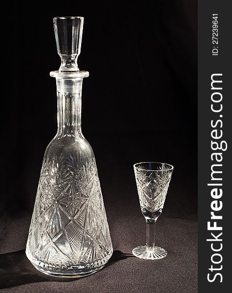 Crystal decanter and glass on the black bacground