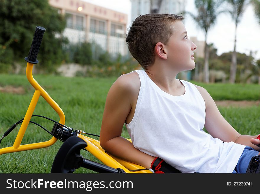 Boy with a bicycle outside in the summer day