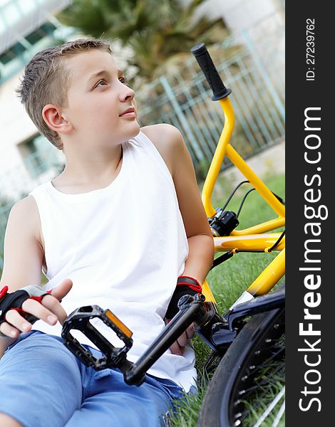 A boy and a bike outside in the summer day