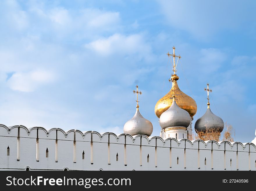 The cupolas of the Cathedral Cathedral of Our Lady of Smolensk behind the fortress wall of Novodevichy Convent, Moscow. The cupolas of the Cathedral Cathedral of Our Lady of Smolensk behind the fortress wall of Novodevichy Convent, Moscow