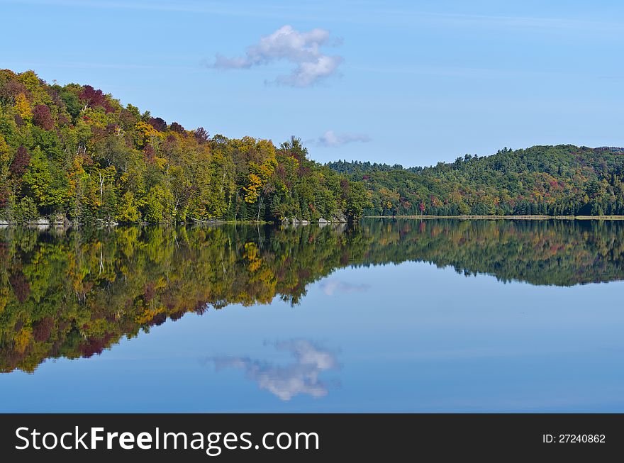 Mountain full of fall colours reflected in Gatineau lake. Mountain full of fall colours reflected in Gatineau lake