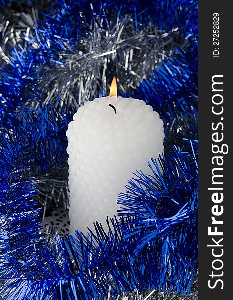 Christmas - Christmas tinsel and a burning candle. Christmas - Christmas tinsel and a burning candle