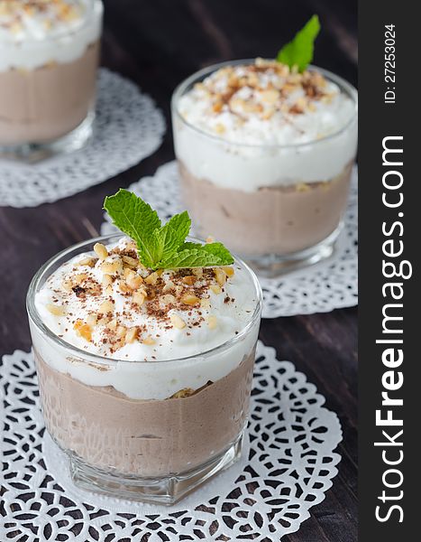 Chocolate dessert with whipped cream in a glass beaker closeup