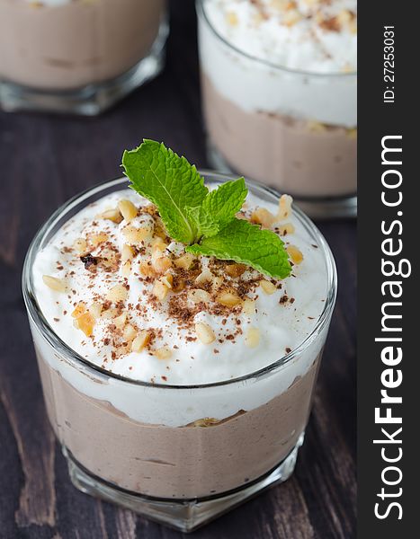 Chocolate dessert with whipped cream in a glass beaker closeup