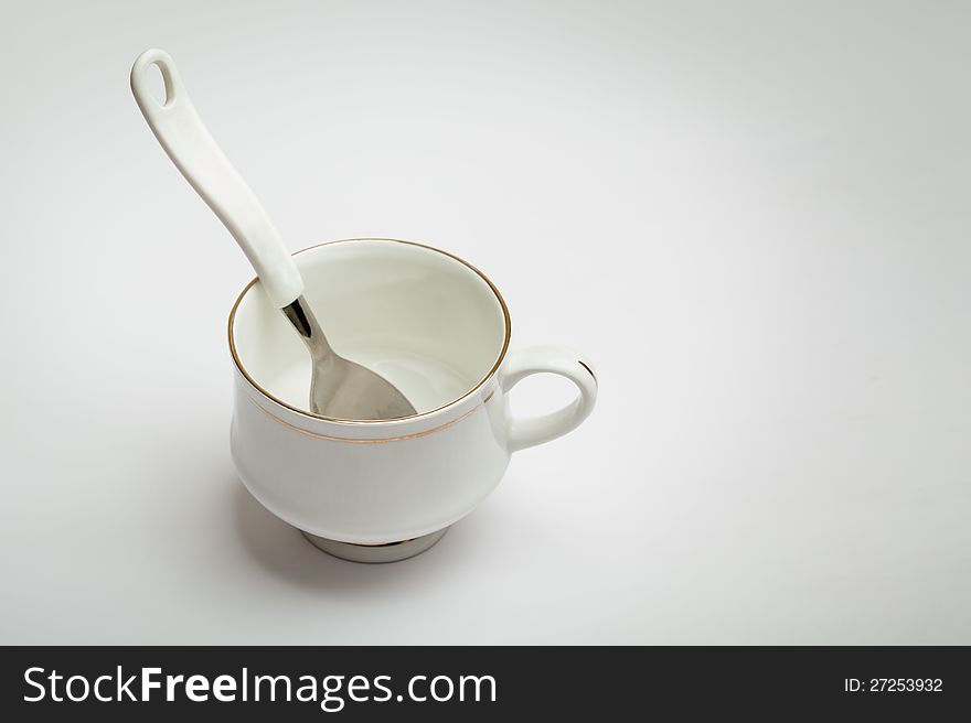 White cup and spoon isolated over white