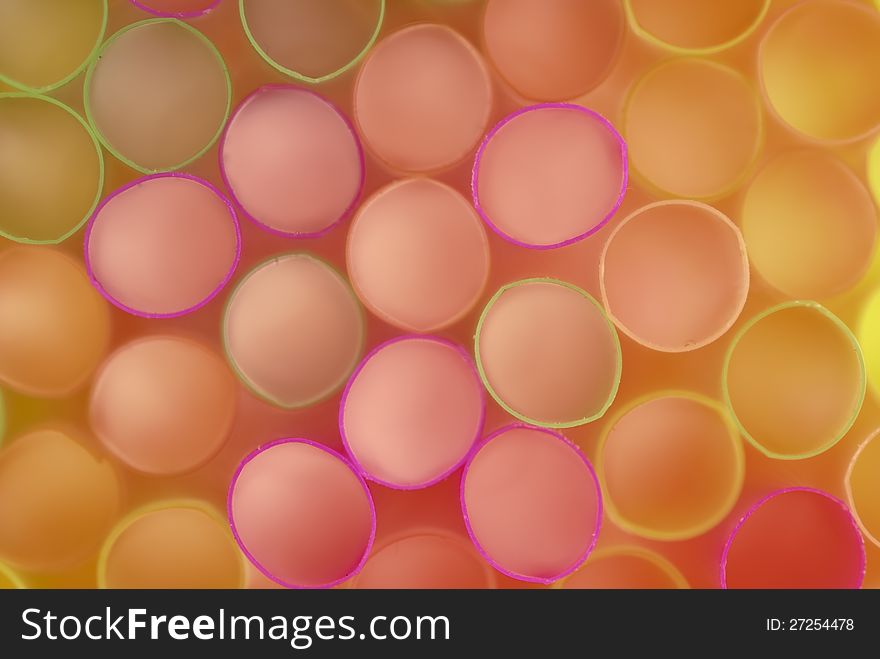 Brightly colored plastic tubes for drinks laid in the background. Brightly colored plastic tubes for drinks laid in the background