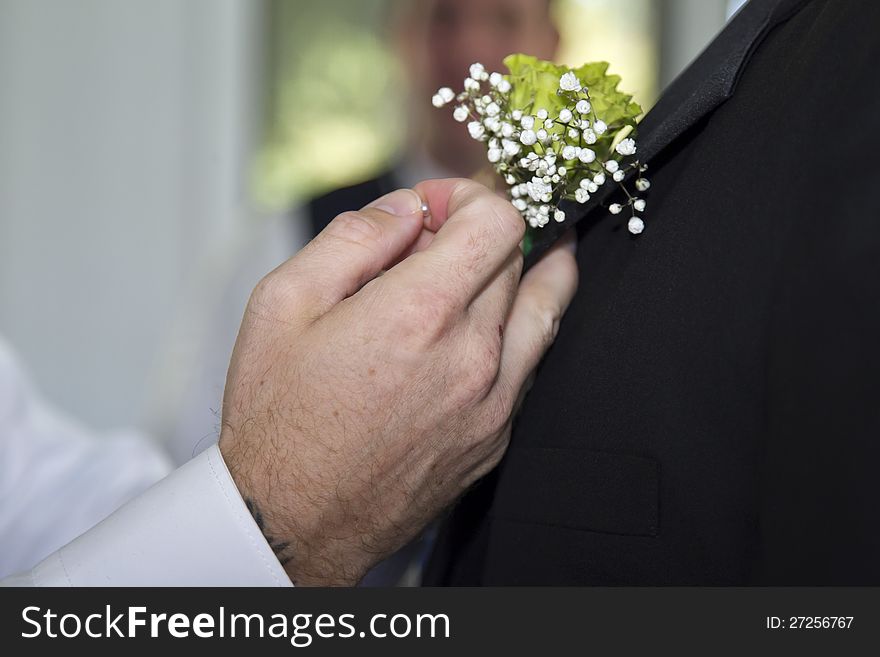 A Boutonniere Is Put On A Groom