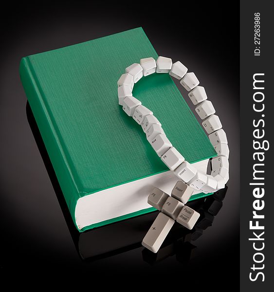 Christian, catholic rosary made from computer keyboard with green book