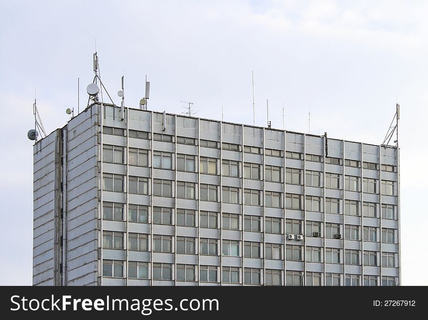 Photo of unusual research building from glass and iron with every possible aerials against sky. Photo of unusual research building from glass and iron with every possible aerials against sky