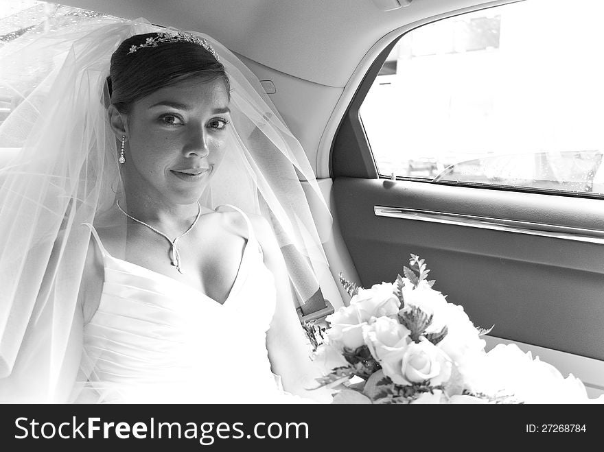 Beautiful bride with flower inside the car