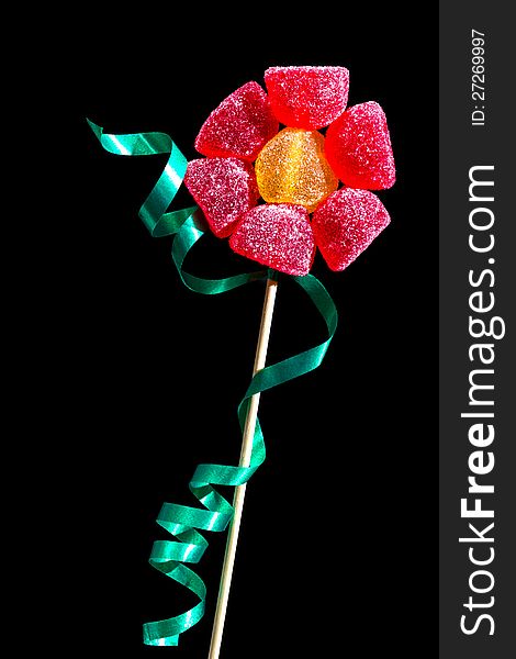 Flower made of gumdrops on a stick with a green ribbon. Flower made of gumdrops on a stick with a green ribbon