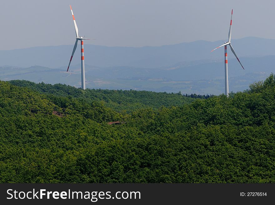 Two wind turbines on a green hill. Two wind turbines on a green hill