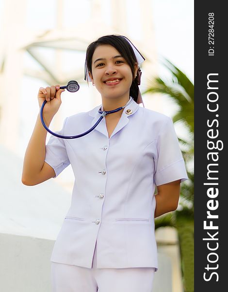 Nurse smiling with stethoscope in the garden