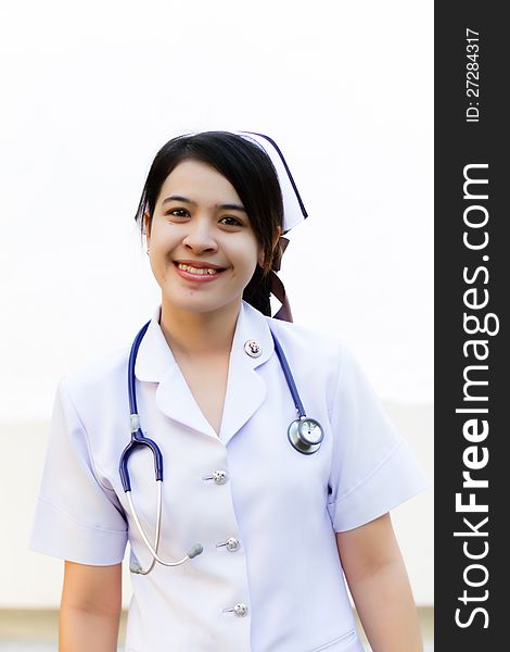 Thai nurse smiling with stethoscope in the garden