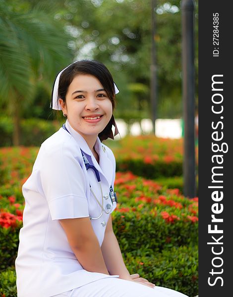 Thai nurse smiling with stethoscope in the garden