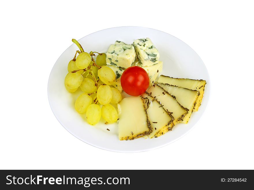 Blue cheese and piquant cheese with bunch of yellow grapes and small red tomato on a plate isolated on white. Blue cheese and piquant cheese with bunch of yellow grapes and small red tomato on a plate isolated on white