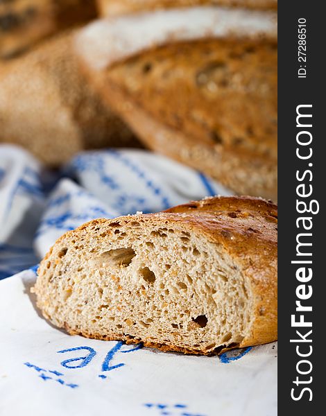 Baked bread sliced, detail. Other breads in background blur