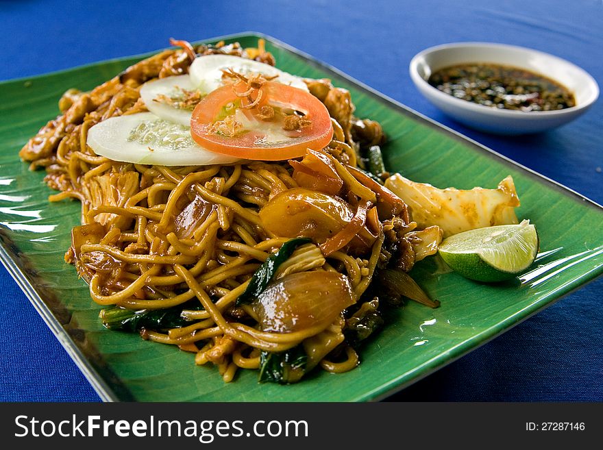 Dish of noodles and vegetables Malaysian style on a plate.