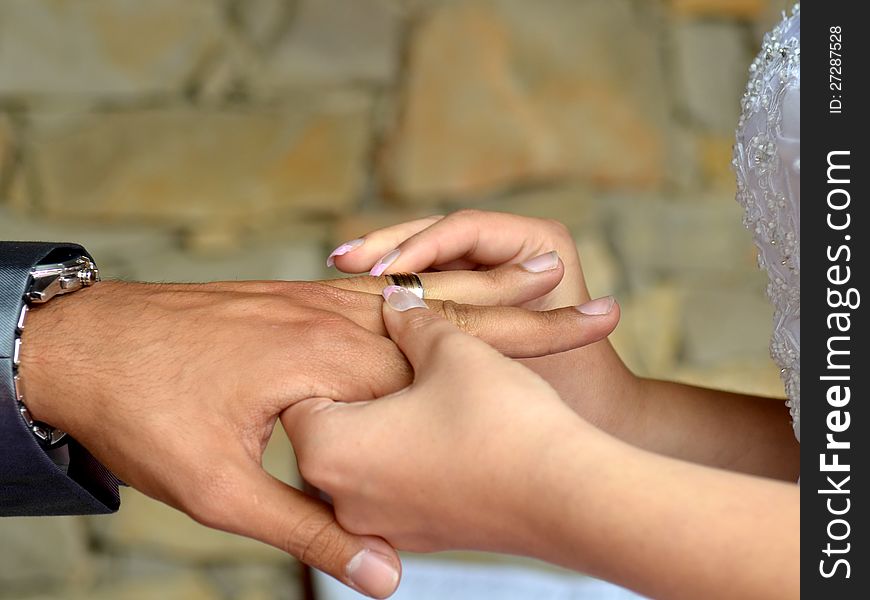 Bride give a wedding ring to the groom