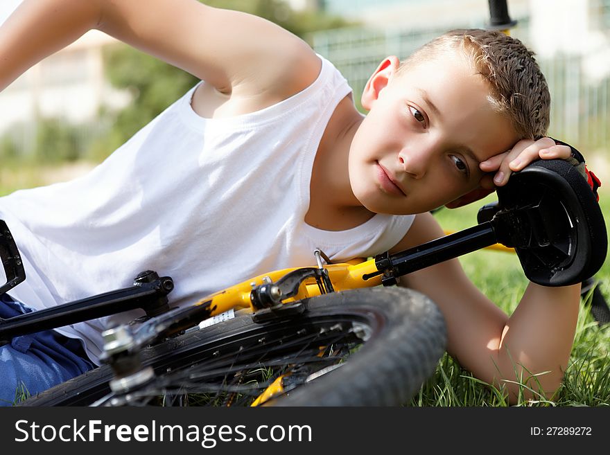 Boy rests with the bike in the park day