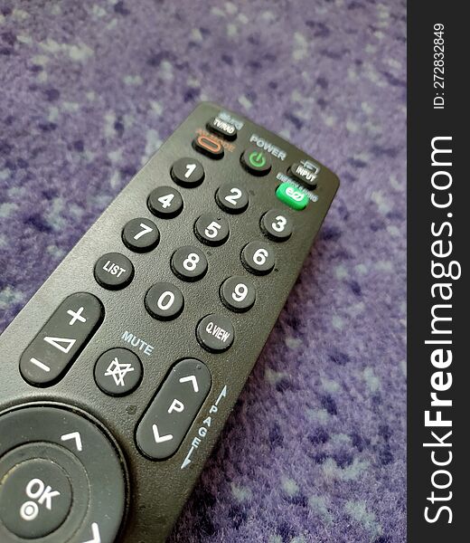 Television Remote Lying on Purple Carpet