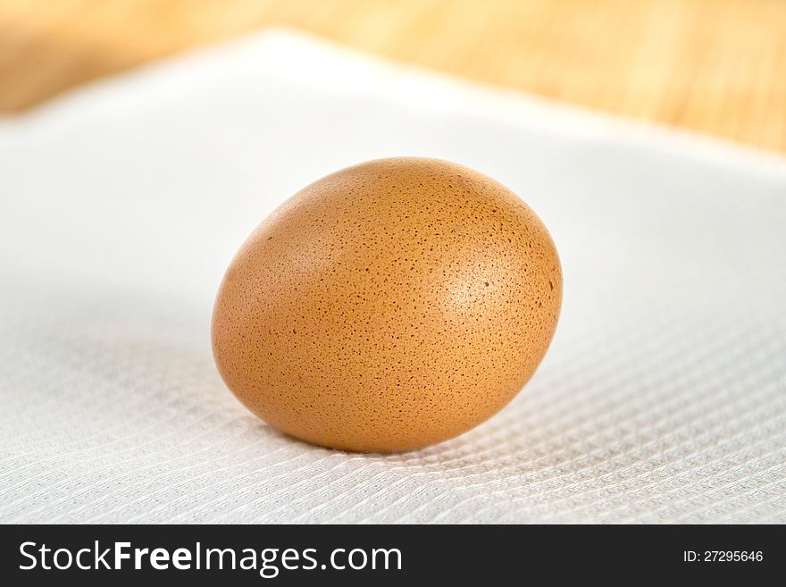 Brown egg on the white kitchen napkin. Brown egg on the white kitchen napkin