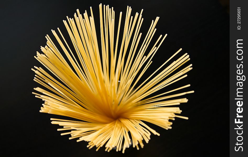 Yellow spaghetti on black background