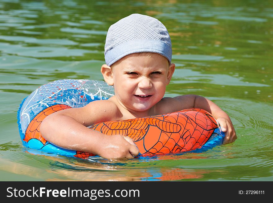 Happy boy swimming in river with rubber ring. Happy boy swimming in river with rubber ring