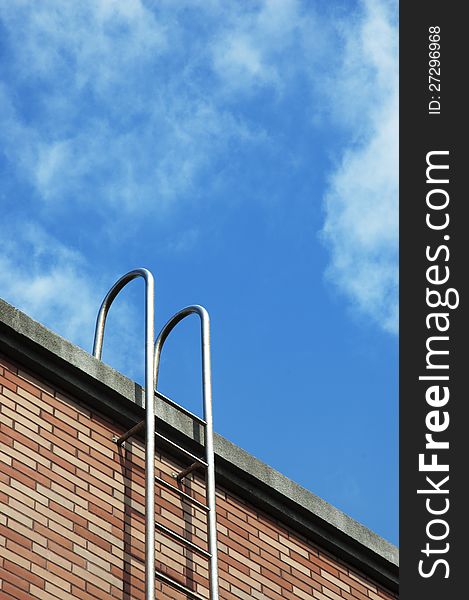 Stainless ladder of roof with blue sky