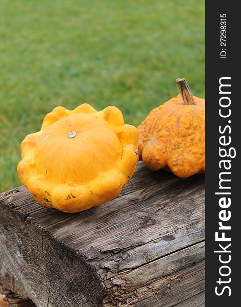 two Orange pumpkins sitting on a wooden table. two Orange pumpkins sitting on a wooden table.