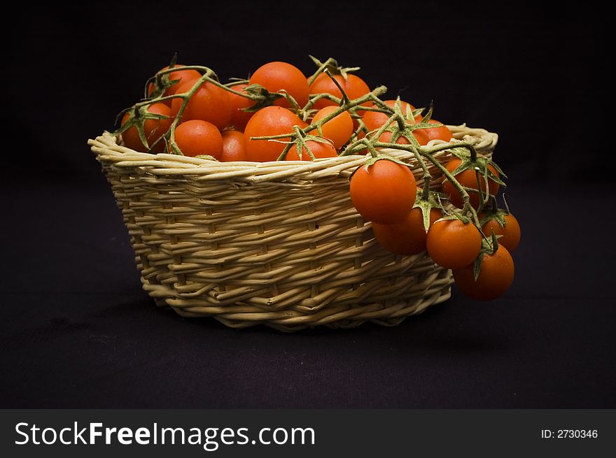 A shoot of pachino's tomato, typical sicily tomato in a basket. A shoot of pachino's tomato, typical sicily tomato in a basket