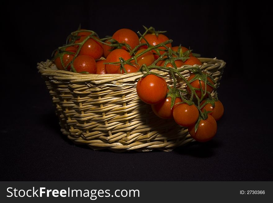 A shoot of pachino's tomato, typical sicily tomato in a basket. A shoot of pachino's tomato, typical sicily tomato in a basket