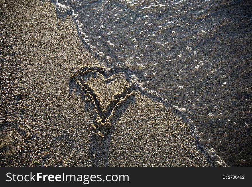 Heart drawn in the sand, beach and water. Heart drawn in the sand, beach and water