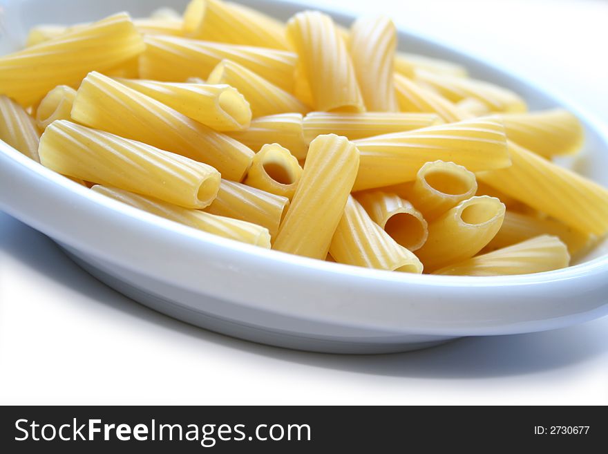 Dish of italian pasta maccheroni rigatoni rigates isolated on white background. Dish of italian pasta maccheroni rigatoni rigates isolated on white background