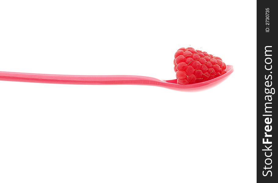 Raspberry on a red plastic spoon